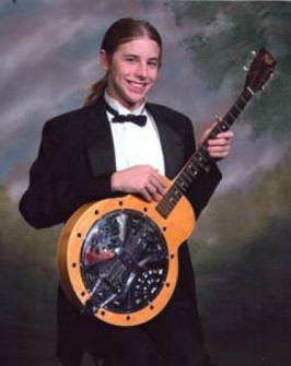 My son, Ian Nathaniel Django Jones, with the dobro banjo I got from Alan Munde. This is his orchestra photo. He was supposed to be holding his violin…