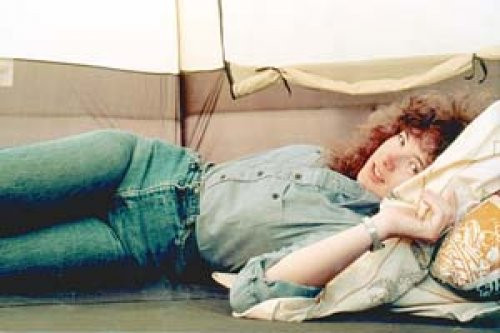 Leigh with 1980's hair in tent at festival.
